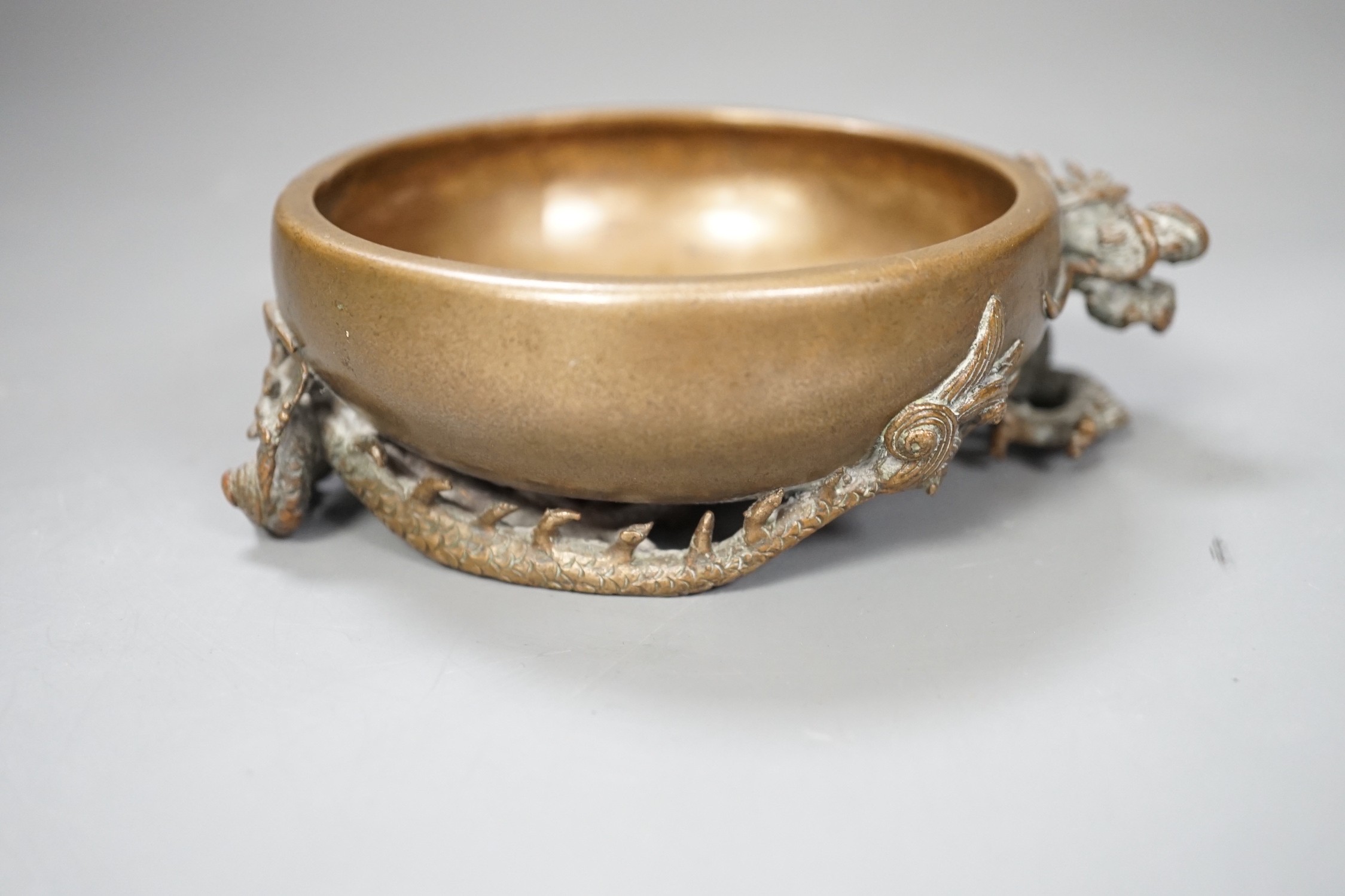 A Chinese or Japanese bronze ‘dragon’ dish, 13cm